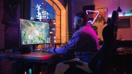 Gaming at Home: Gamer tragen Kopfhörer und spielen Online-Videospiele am Computer. Stilvolle schwarze männliche Spieler genießen RPG Strategy Arcade Online