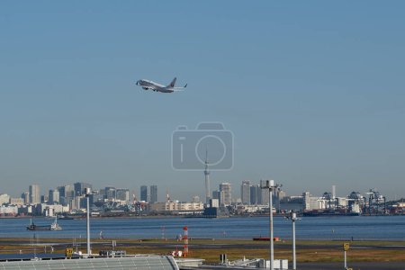 Photo for Tokyo, Japan  Nov.20th, 2023: Japan Airlines airplane taking off from Tokyo Haneda Airport with the Tokyo Skytree and the background of the skyscrapers. - Royalty Free Image