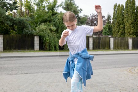 Foto de Niña en edad de la escuela primaria feliz, niño bailando por la calle solo, espacio para copiar, una persona, fondo borroso. La felicidad y la libertad de la infancia libre de estrés, concepto de niño descuidado, sin preocupaciones - Imagen libre de derechos