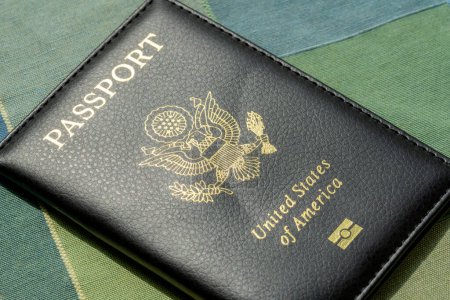 United States of America, USA passport cover laying on a table, object closeup, detail, nobody, no people. Legal immigration, emigration, visa simple abstract concept, entry permit, laws and policies