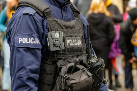 Oficial de policía polaco, policía anónimo irreconocible en un chaleco negro bodycam, cámara corporal, radio, accesorios y equipo de detalle, primer plano, una persona. Servicios de emergencia concepto simple