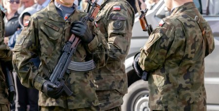 Photo for Krakow, Poland, two professional Polish soldiers on the street in camo uniforms holding machine guns, weapons closeup. Professional army, war warfare, infantry - Royalty Free Image