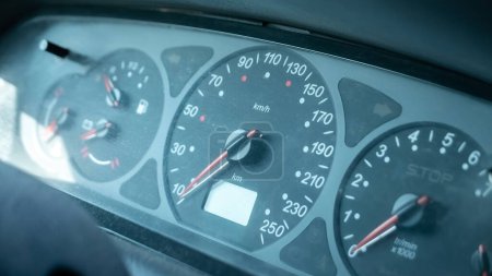 Photo for A simple dusty old speedometer in a generic motionless stopped car interior, object detail, closeup, vehicle dashboard dials cinematic movie still shot. Meter showing speed in kilometers per hour, kmh - Royalty Free Image