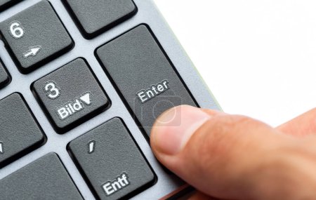 Vista de cerca de un dedo de personas a punto de presionar la tecla Enter en un teclado numérico de un teclado negro elegante, acción de finalizar una entrada, cálculos finales concepto abstracto, una persona