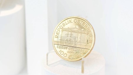 Foto de Moneda de oro puro, República de Austria, inscripción grabada 1 Unze Gold 999.9 en un soporte pequeño, valor de 100 euros, alta pureza y valor, inversiones en metales preciosos - Imagen libre de derechos