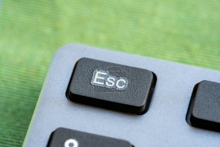 Makroaufnahme, die eine ESC-Taste einer modernen Tastatur zeigt, Objektdetail, extreme Nahaufnahme Makro, niemand. Escape-Charakter-Taste, Flucht, Schließen einer App, Aufhebung einfachen abstrakten Konzepts, keine Menschen