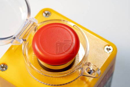 Detaillierte Nahaufnahme eines roten Not-Aus-Knopfes für die industrielle Maschinensicherheit, roter gelber Panikknopf mit geöffnetem Deckel. Schwere Ausrüstung, Sicherheit am Arbeitsplatz, Sicherheit der Arbeitnehmer
