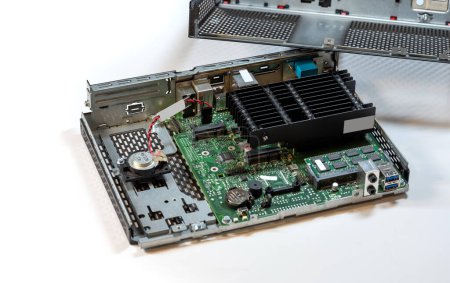 Opened passively cooled computer terminal, displaying showing internal parts, components. Motherboard, heatsink, and various connectors on display, desktop PC service and repair abstract concept