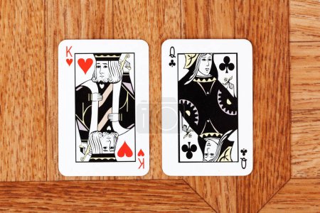 King of hearts card and Queen of clubs card placed side by side, facing each other, opposition and differences between man and woman social cultural societal role issues symbol abstract concept, top