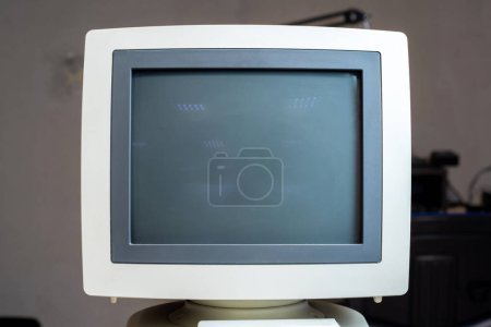 Un monitor CRT vintage con pantalla en blanco, relación de aspecto 4: 3, pantalla de tubo de rayos catódicos de computación retro, viejas piezas de equipos de ciencia de oficina corporativos, vista frontal, disparo frontal, nadie. Hardware fechado
