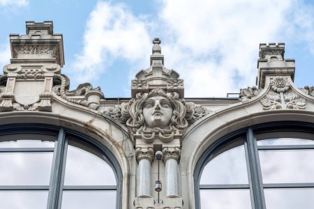 Nahaufnahme der architektonischen Details des historischen Postgebäudes in Breslau, mit skulpturalen Elementen und kompliziertem Mauerwerk vor bewölktem Himmel