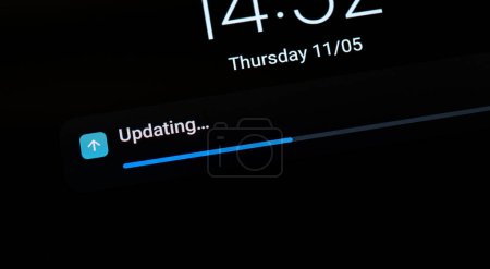 Progress bar indicating an ongoing OS operating system update on a generic mobile device, smartphone, tablet, nobody, screen display macro detail closeup shot. Updating software abstract concept