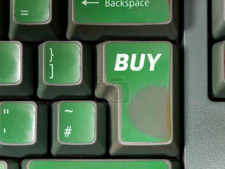 Abgenutzte grüne Eingabetaste mit dem Wort KAUFEN auf einer alten Trader-Computertastatur. Börsenhandel, Kauf, Tageshandel Kryptowährung, Bullenmarkt KI-Handel bot abstraktes Konzept