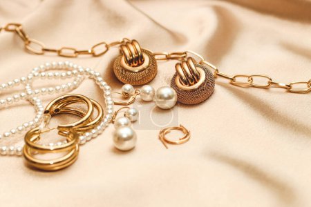 Téléchargez les photos : Bijoux femme, chaîne dorée, bijoux tendance sur fond de soie. - en image libre de droit
