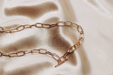 Foto de Joyas para mujer, cadena dorada, joyas de moda sobre fondo de seda. - Imagen libre de derechos