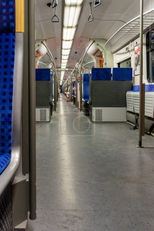 Téléchargez les photos : L'intérieur d'un wagon de voyageurs voyait un angle bas le long de l'allée entre les rangées de sièges bleus - en image libre de droit