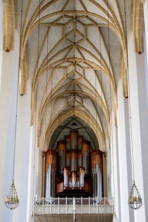 Téléchargez les photos : Longue vue télescopique dans le couloir en bas de la cathédrale avec des lustres suspendus à la voûte de plafond de type nervure - en image libre de droit
