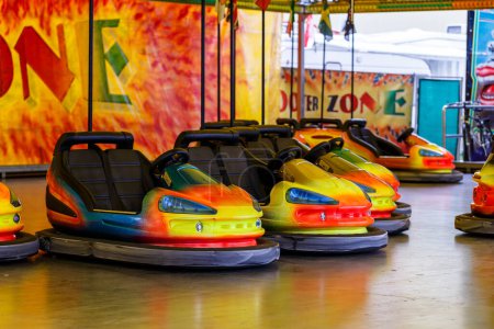 Téléchargez les photos : Voitures pare-chocs colorées lumineuses à un parc des expositions prêt à être loué sur une patinoire couverte - en image libre de droit