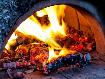 Foto de Un horno para hornear pizza con leña ardiendo en el interior. - Imagen libre de derechos