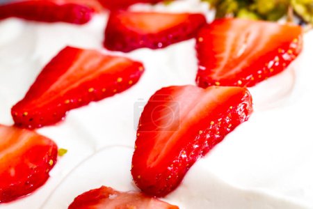 Téléchargez les photos : Tranches de fraise en gros plan sur le dessus blanc du gâteau - en image libre de droit
