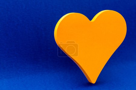 Téléchargez les photos : Papier jaune en forme de coeur avec espace de copie ; fond bleu - en image libre de droit