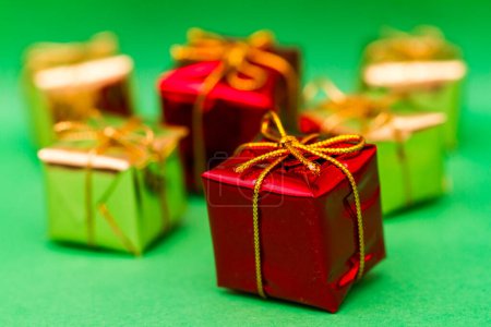 Téléchargez les photos : Groupe de boîtes-cadeaux rouges et or reculant au loin sur fond vert. - en image libre de droit