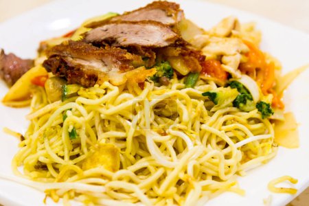 Photo for Close Up Still Life of Noodle Dish with Pork and Mixed Vegetables Served on White Plate - Chow Mein or Spaghetti Noodle Meal with Meat and Veggies - Royalty Free Image