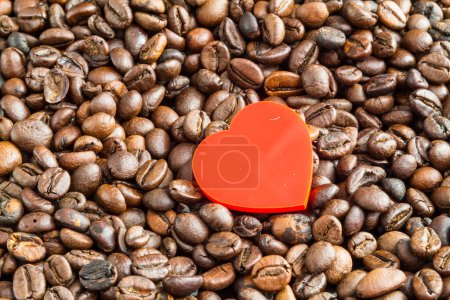 Téléchargez les photos : Un petit cœur rouge sur fond de grains de café torréfiés. - en image libre de droit