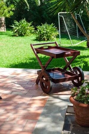 Foto de Un patio trasero con un carrito de jardín y una piscina. . - Imagen libre de derechos