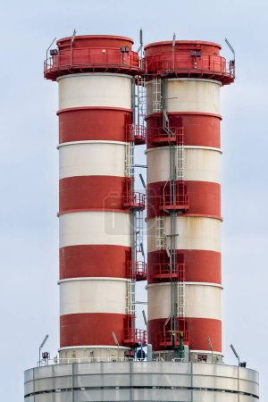 Téléchargez les photos : Fumées industrielles rayées rouges et blanches empilées contre le ciel bleu. - en image libre de droit