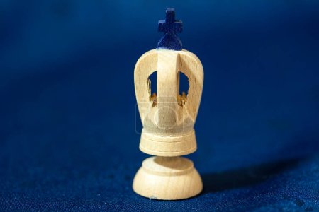Photo for Carved wooden King Chess piece with dark blue cross on a blue background. - Royalty Free Image