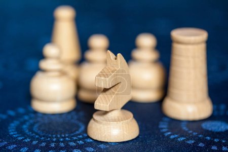 Photo for Group of white wooden chess pieces, focus on knight in foreground. - Royalty Free Image