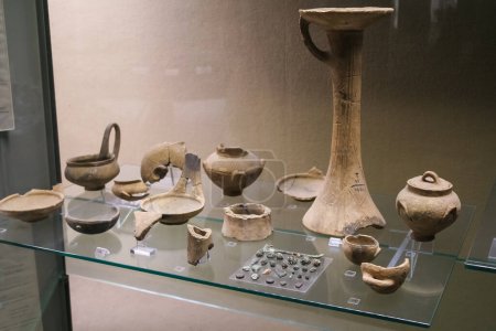 Téléchargez les photos : Plusieurs objets anciens exposés sur une étagère en verre dans un musée archéologique. - en image libre de droit