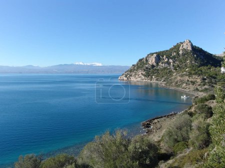 Téléchargez les photos : Une vue du coût typique en grec avec des montagnes sur l'orizon et la mer - en image libre de droit