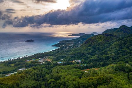 Photo for Aerial view of Grand Anse Beach at the Mahe Island, Seychelles, with heavy clouds, Indian Ocean, local villages, mountains and rain forests. - Royalty Free Image