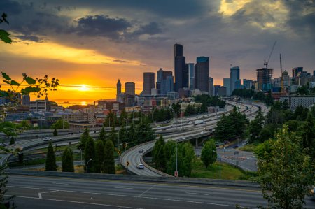 Foto de Atardecer dramático sobre el horizonte del centro de Seattle, con tráfico en el intercambio de autopistas I-5 y I-90, visto desde el puente Dr. Jose Rizal. - Imagen libre de derechos