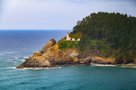 Photo for Heceta Head Lighthouse on the Pacific Coast amidst rugged mountains, overlooking the expansive Pacific Ocean near Florence, Oregon. A popular landmark and tourist attraction. - Royalty Free Image