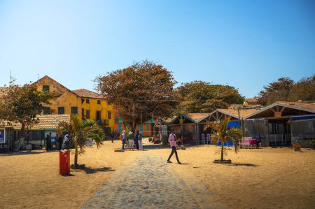 Téléchargez les photos : Goree, Sénégal - 01 mars 2023 : Bâtiments colorés et rues sablonneuses de Goree Island avec des touristes. Goree Island est connue pour son importance historique en tant que centre de la traite transatlantique des esclaves. - en image libre de droit