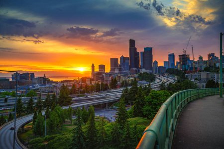 Photo for Dramatic sunset over the Seattle skyline, with traffic on the I-5 and I-90 freeway interchange, viewed from Dr. Jose Rizal Bridge. - Royalty Free Image