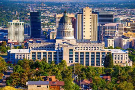 Edificio del Capitolio Estatal de Utah con el horizonte de Salt Lake City en el fondo. El capitolio es el edificio principal del Complejo del Capitolio Estatal de Utah, que se encuentra en Capitol Hill..