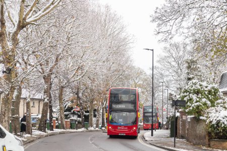 Photo for LONDON, UK - 13TH DECEMBER 22: Public double decker buses on roads during the winter months when there's snow. - Royalty Free Image