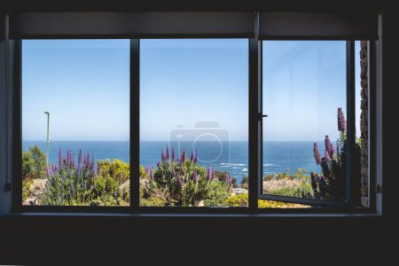 Téléchargez les photos : Grande fenêtre avec belle vue sur le paysage marin, l'herbe et les fleurs de lavande par une journée ensoleillée - en image libre de droit