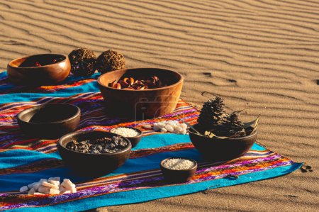 Foto de Viaje místico andino: manta peruana, charango, cristales e incienso de madera sagrada ardiente en la arena del desierto - Imagen libre de derechos
