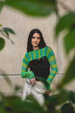 Photo for Enchanting latina charm: beautiful brunette model with a green knitted sweater in a sunny day in the park - Royalty Free Image