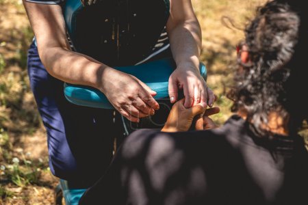 Toque curativo: masajista realiza con la mano un masaje de manos en un entorno natural