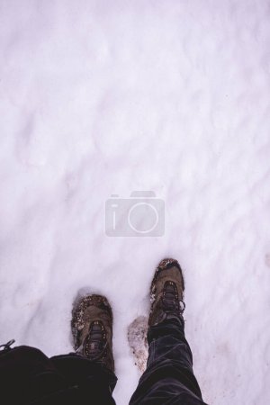 Winter's trek: a solitary journey through deep snow, first-person steps cutting through white and untouched snow
