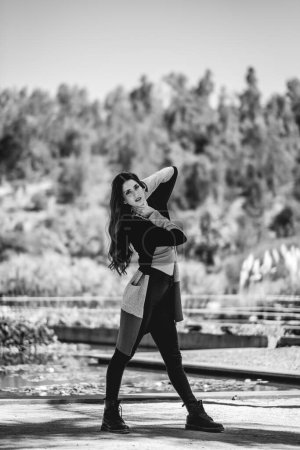 Téléchargez les photos : Latina beauté et mode : belle mannequin brune avec un look mode dans une journée ensoleillée dans le parc (en noir et blanc) - en image libre de droit