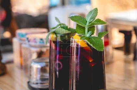 Téléchargez les photos : Dégustation de cocktails estivaux : plan rapproché d'un cocktail de vin froid vibrant aux fruits et à la menthe - en image libre de droit