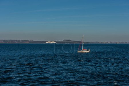 Photo for Horten, Norway - April 17 2022: Sailboat heading north and DFDS ferry heading south in the Oslofjord at Horten. - Royalty Free Image
