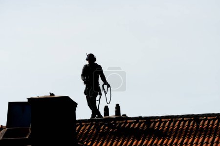 Photo for Gothenburg, Sweden - May 06 2020: Silhouette of a chimney sweeper on top of a roof. - Royalty Free Image
